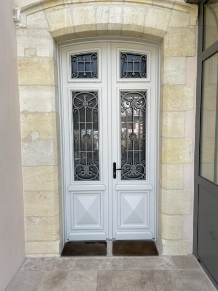 Porte d’entrée en bois avec vitrages décoratifs et grille de defense